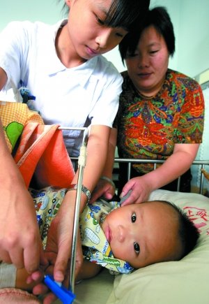 2008年9月13日，醫(yī)務人員為10個半月大的腎衰竭患兒換藥，該患兒因喝三鹿奶粉而患病。新華社記者 陳飛 攝